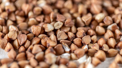 Essential goods: Buckwheat. Buckwheat seed pour in bunch closeup. Buckwheat cereal background.