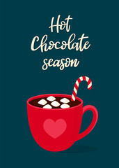Hot chocolate with marshmallow in a red mug on a dark blue background. Handwritten text 