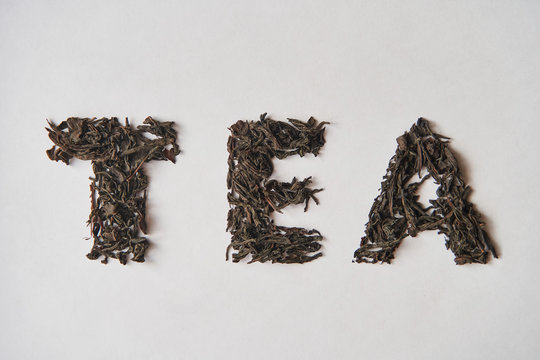 Leaf tea. The inscription TEA on a white background. Lettering Tea made by loose tea.