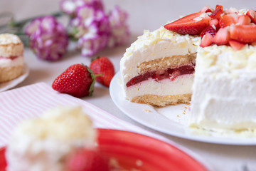 Torte und Törtchen mit Quark und Sahne und weißer Schokolade und Erdbeeren