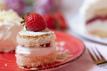 Torte und Törtchen mit Quark und Sahne und weißer Schokolade und Erdbeeren