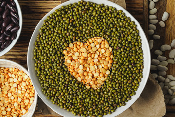 Assortment of beans on wooden background.