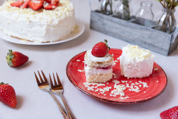 Torte und Törtchen mit Quark und Sahne und weißer Schokolade und Erdbeeren