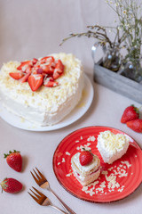 Torte und Törtchen mit Quark und Sahne und weißer Schokolade und Erdbeeren