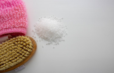 Sea salt, washcloth, body massage brush on a white background