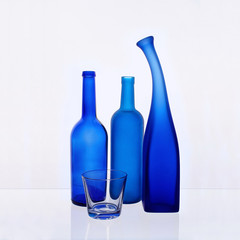 Still life with colored bottles on a white background