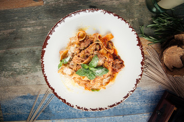 Top view on spaghetti tagliatelle with meat and parmesan cheese garnished with basil leaves, horizontal