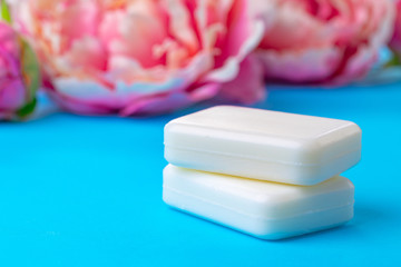 Bars of handmade soap with flowers on the table, close up