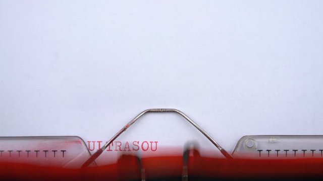 Ultrasound examination - phrase printed on an old typewriter in red letters, close up. vintage inscription