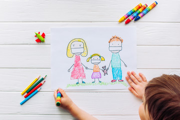 Little girl drawing a picture of family in face masks on white background