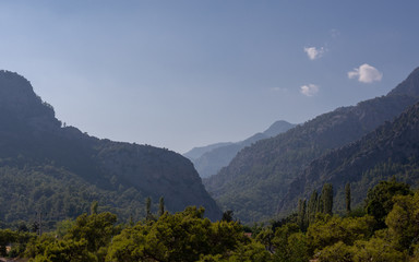 Mountain silhouette in haze. Nature background with mountain silhouettes. Mountain hills are densely covered with trees. Turkey.