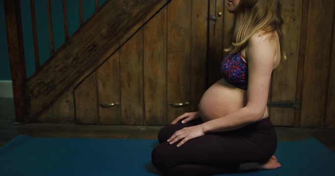 Pregnant young yoga woman doing breathing exercises