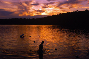 Fototapeta premium A Swimmer Emerges from Walden Pond, Massachusetts at Sunset