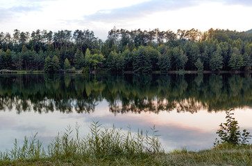 beautiful lake with forest landscape and sunset on water, mirror reflection on  water 