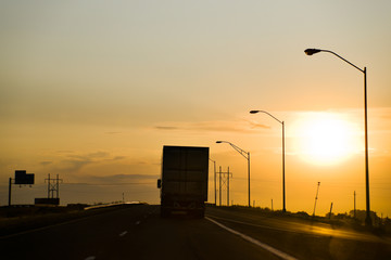 Big Rig Drives toward Sunset on US Interstate Highway