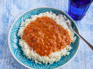 Rice with tuna sauce on rustic blue background,