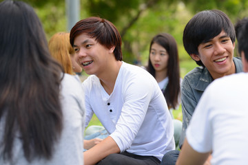 Happy young group of friends having fun together at the park