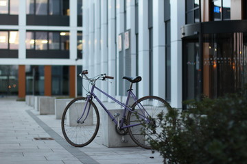 Old bike on the street with the white office building on the background