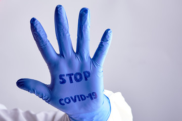 hand medical rubber glove with the inscription stop covid19