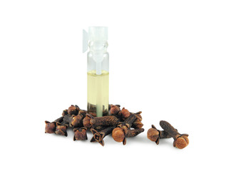 Clove oil in small glass bottle surrounded by dry clove buds isolated on white background. Spice, food flavoring and natural cosmetic ingredient.
