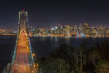 Plakat Illuminated Bridge Over Calm River At Night