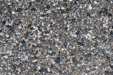 Crushed rubble and stones, granite chips closeup. Rough granular surface, gravel texture as an abstract background for your design