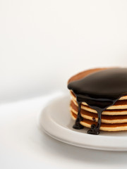 pancakes with dressing chocolate on white plate on white background