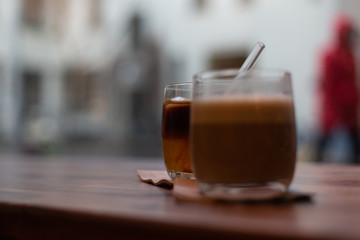 A glass of hot and cold coffee in a cafe.  Cold brew and cappuccino coffee.  