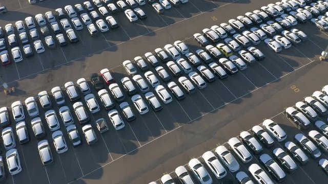 Aerial top down view of cars symmetrical lined up at parking lot