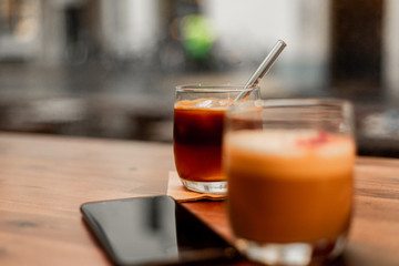 A glass of hot and cold coffee in a cafe.  Cold brew and cappuccino coffee.  
