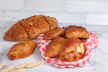 Homemade stuffed pies, bread on a concrete table, concept of healthy and natural food, useful breakfast, top view, place for a recipe. Traditional rustic Russian style,