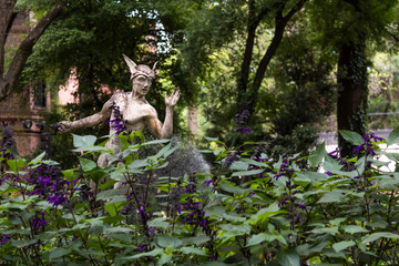 Naklejka na ściany i meble Hermes sculpture in purple garden