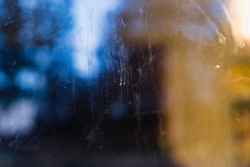 abstract blue and yellow night photographed through a dirty smudged window
