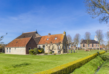 Fototapeta na wymiar Historic farm and church in small town Sondel, Netherlands