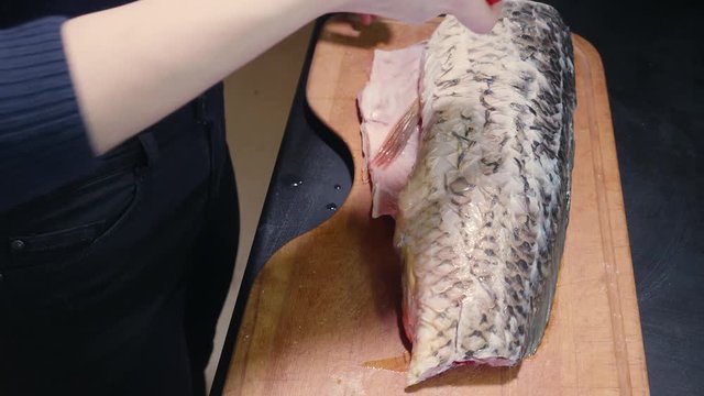 Girs hands put salt on fish fillet before putting it into oven