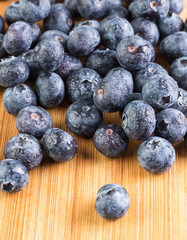 Fresh blueberry in white plate photographed against wooden background