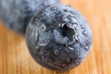 Fresh blueberry in white plate photographed against wooden background