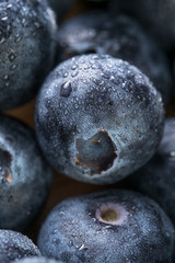 Fresh blueberry in white plate photographed against wooden background