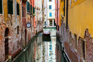 Fototapeta na wymiar A motor boat on tight venetian channel