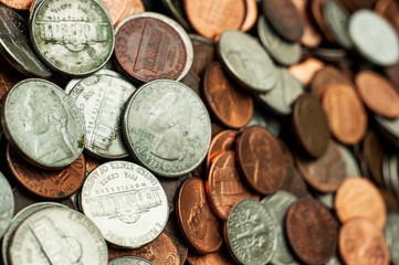 Scattered U.S. currency coins filling the frame.