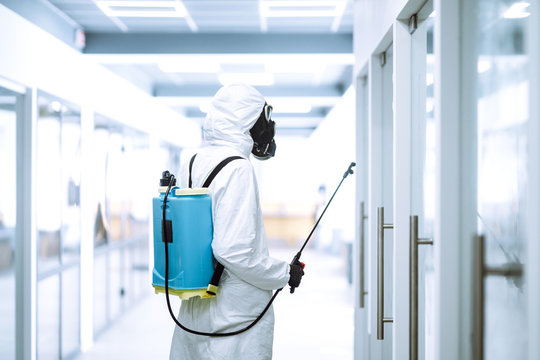 Disinfecting of office to prevent COVID-19, Man in protective hazmat suit with  with spray chemicals to preventing the spread of coronavirus, pandemic in quarantine city. Cleaning concept.