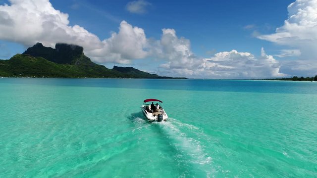 Beautiful drone scenic landscape shot of tropical island honeymoon destination Bora Bora, French Polynesia. Sunshine over the turquoise blue waters of the south pacific paradise lagoon