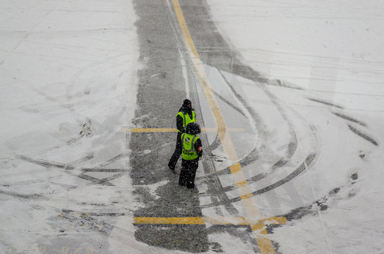 Airport Workers Waiting for the Airplane in the Middle of the Blizzard, New York City, USA