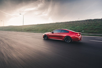 Red sport model cab in a cloudy weather on the highway