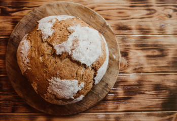 Grain Artisan Bread Loaf. Rustic loaf of homemade bread sliced on dark wooden table. Homemade Loaf Of Bread. Overhead view. Right place for the test