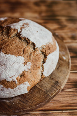 Grain Artisan Bread Loaf. Rustic loaf of homemade bread on dark wooden table. Homemade Loaf Of Bread. Overhead view. Vertical photo