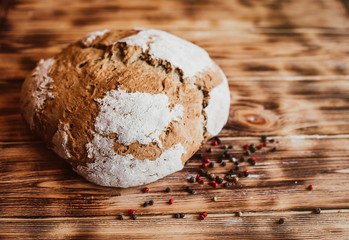 Grain Artisan Bread Loaf. Rustic loaf of homemade bread son dark wooden table. Homemade Loaf Of Bread with spices. Overhead view