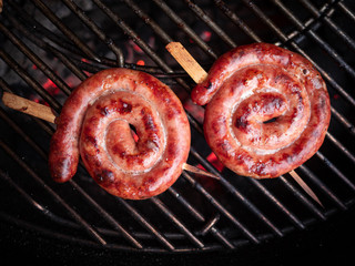 Closeup of two sausage snails on the grill