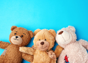 various teddy bears lie on a blue background head to head and look up
