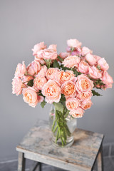 Flower shop delivery concept. Roses of multicolor, pastel pink and pale orange color. Lots of buds. Floral natural background